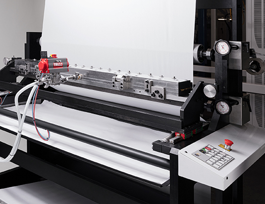 Slot die coating station for water-based and solvent-based adhesive application